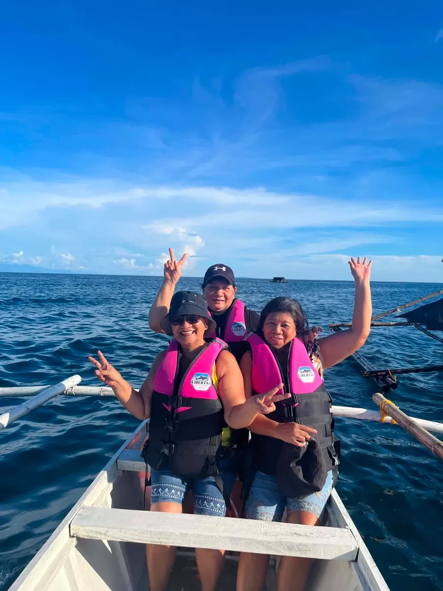 Guests waving from a boat on open water