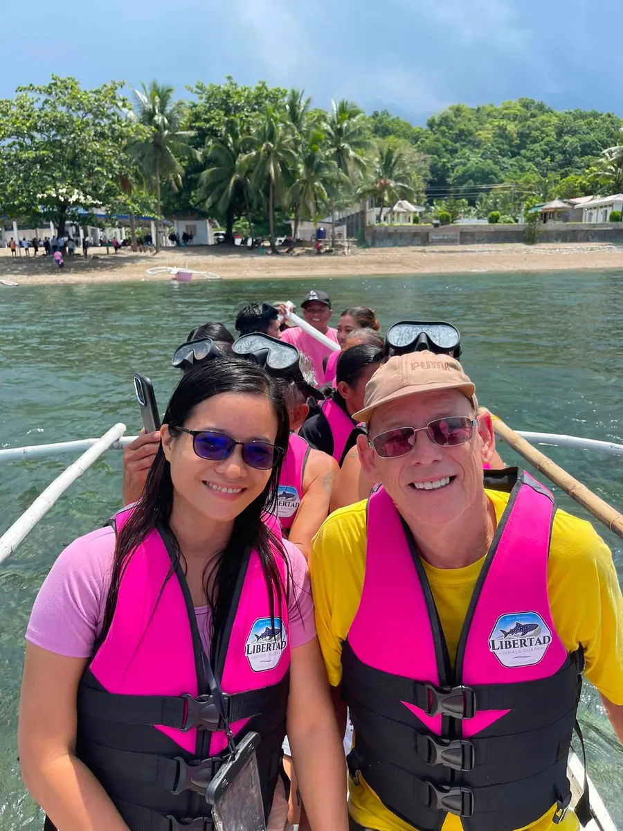 Guests smiling together in a boat near shore