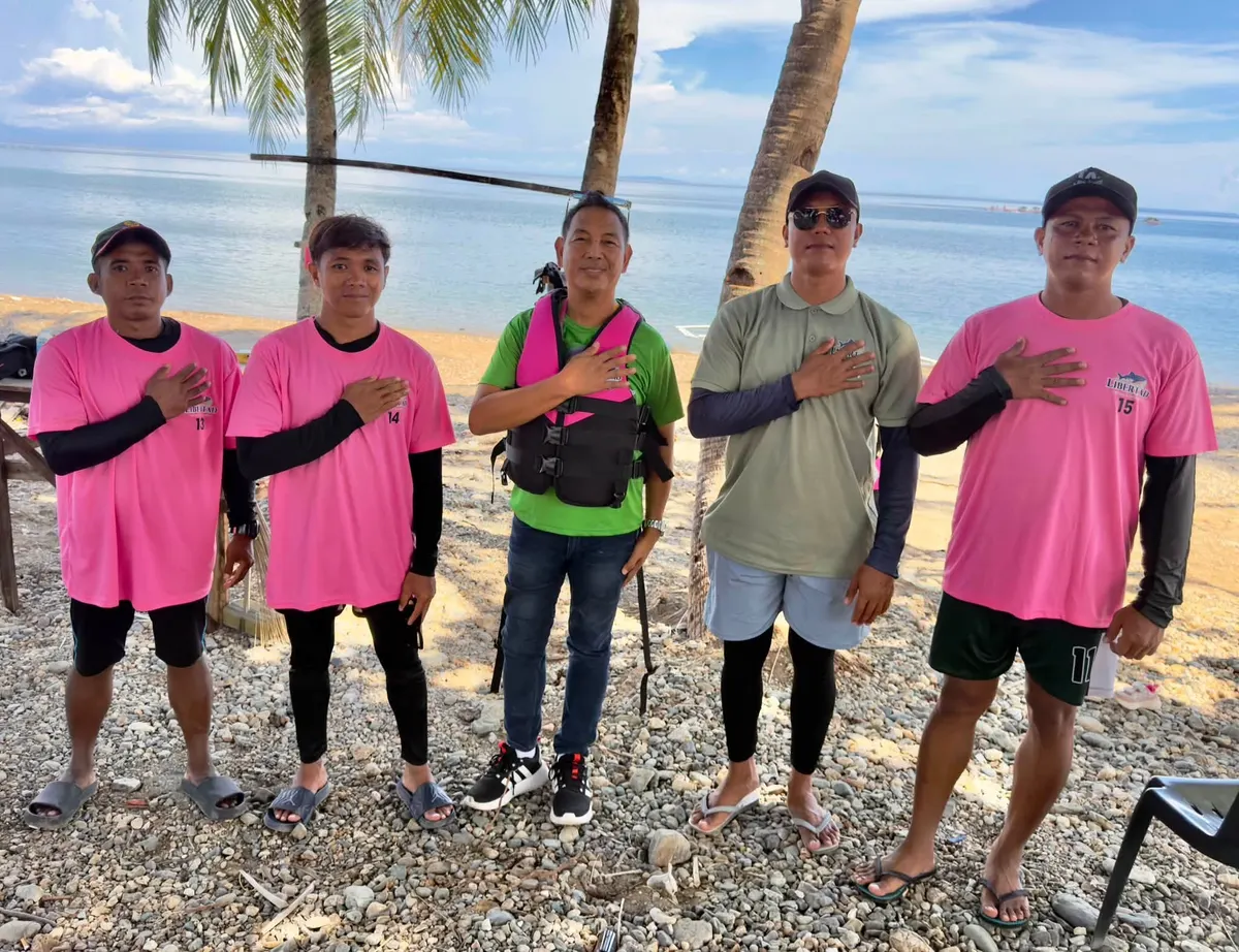 Staff and guests standing together by the beach