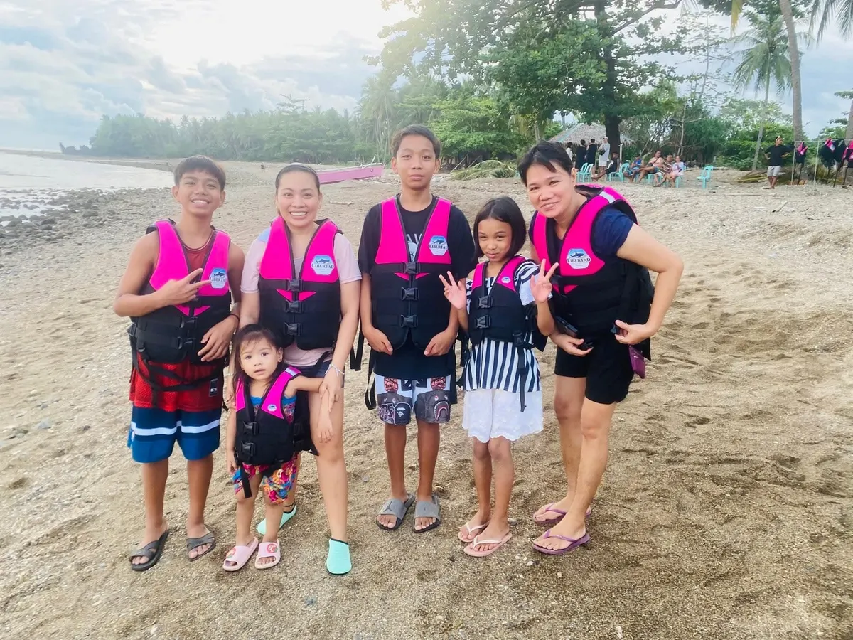 Family guests posing on the shoreline in life vests