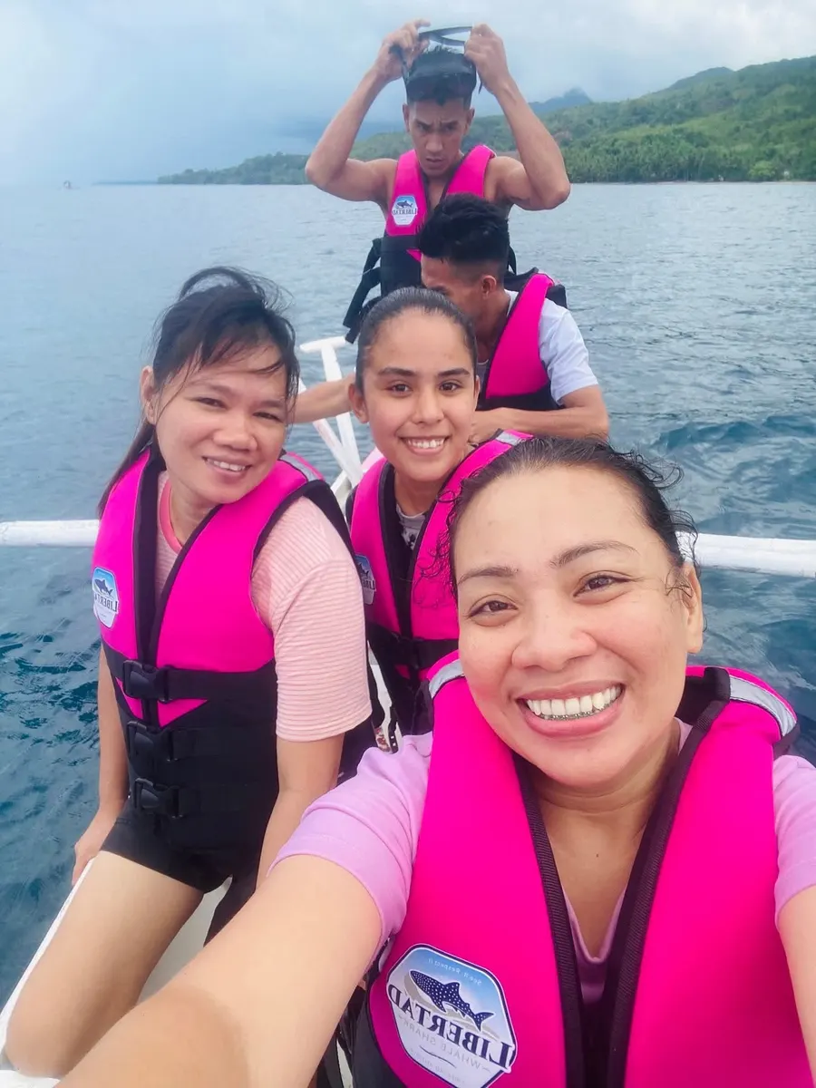 Guests taking a smiling selfie on a boat