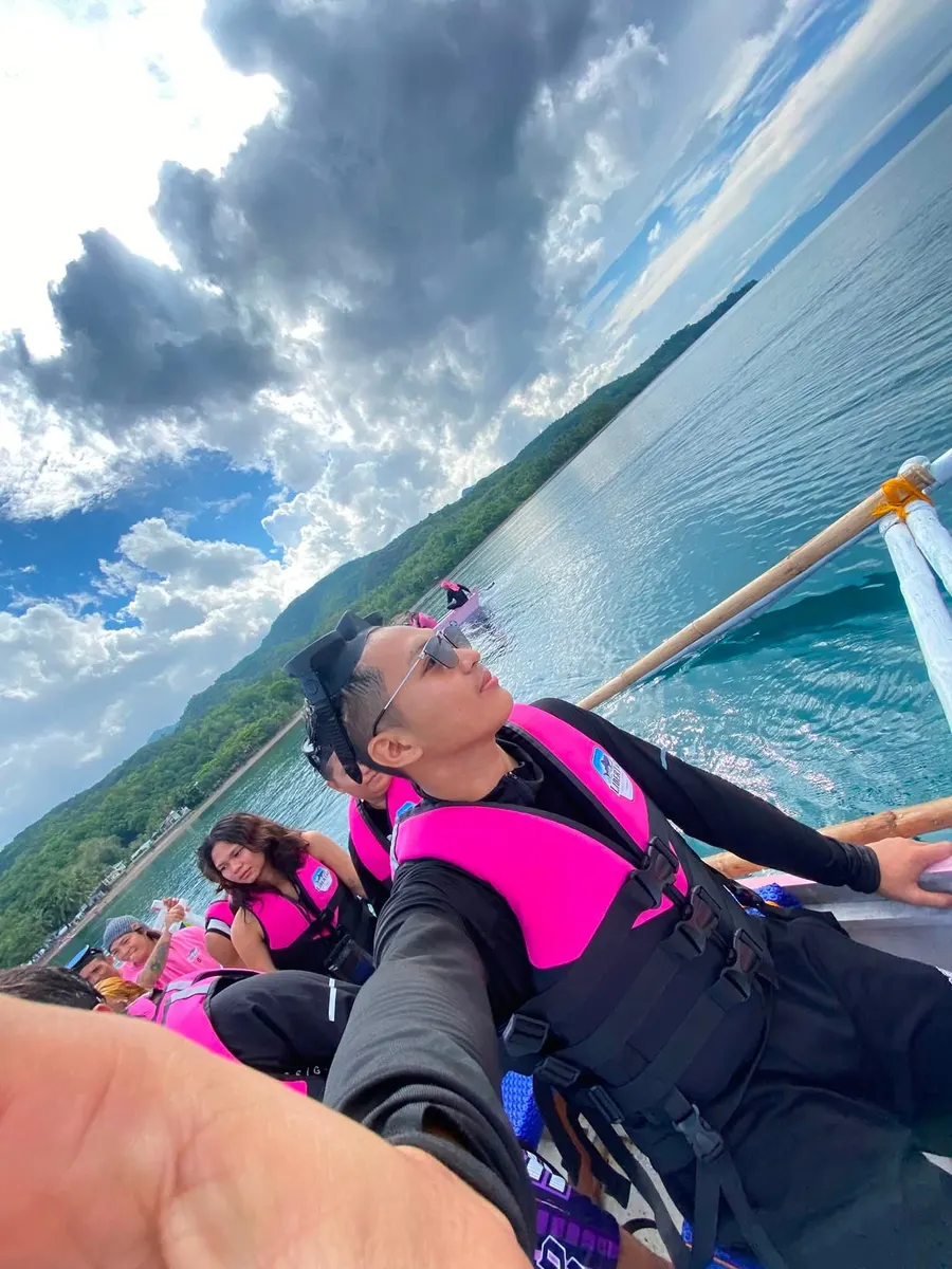 Guest selfie on a boat under dramatic clouds